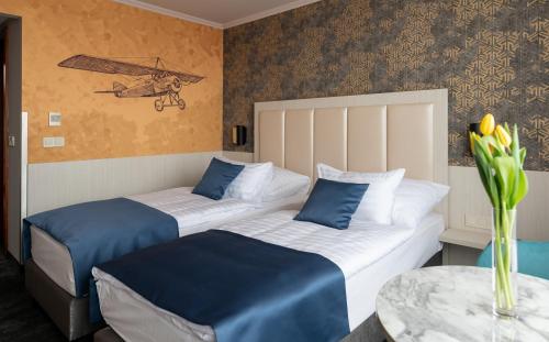 2 camas en una habitación de hotel con mesa en Airport Hotel Budapest, en Vecsés