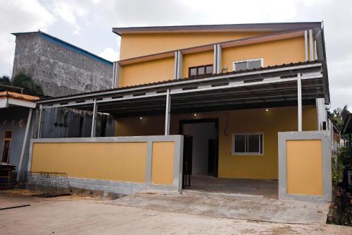 una casa amarilla con un garaje delante en Super OYO 92626 Good Sleep 4 Inn Dcos Syariah, en Samarinda