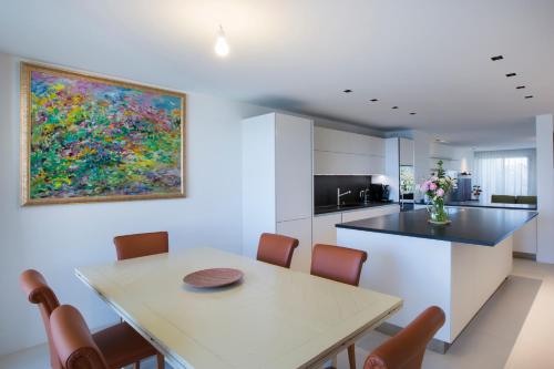 une cuisine avec une table à manger et un tableau mural. dans l'établissement Apartment Lara Light apartment with an incredible view, à Cannes