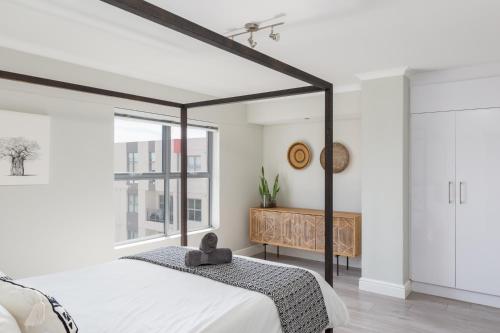 Un dormitorio con una cama grande y una ventana en The Paragon Cosmo Sanctuary Sophisticated Mountain & City Views, en Ciudad del Cabo