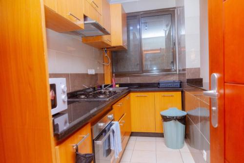 a kitchen with wooden cabinets and a sink and a window at BELMANN BONAPRISO in Douala