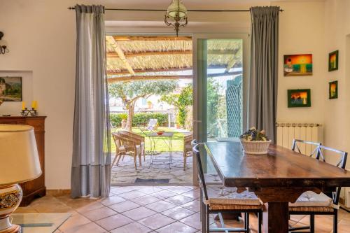 马萨鲁布朗斯Villa Marghe - Sea View Rooms的一间带木桌和庭院的用餐室