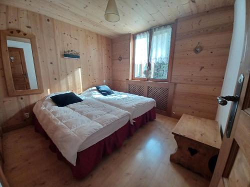 a bedroom with a bed in a wooden room at Lou Darbelots in La Giettaz