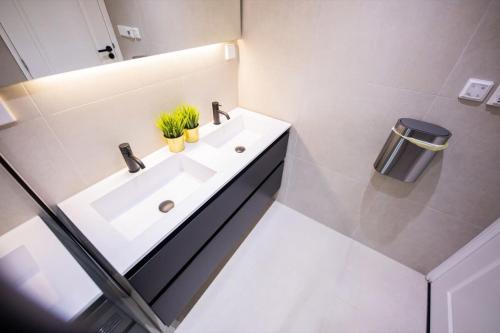 een witte badkamer met een wastafel en een spiegel bij Grandly 3 Bedroom Serviced Apartment 83m2 -NB306G- in Rotterdam
