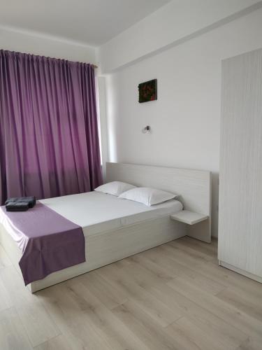 a bedroom with a bed with a purple curtain at Bedaleyl in Piteşti