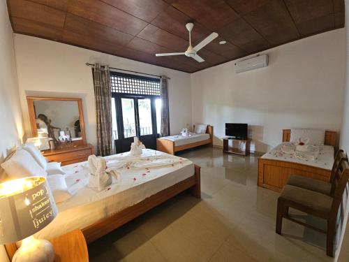 ein großes Schlafzimmer mit einem großen Bett und einem Stuhl in der Unterkunft Gamodh Citadel Resort in Anuradhapura