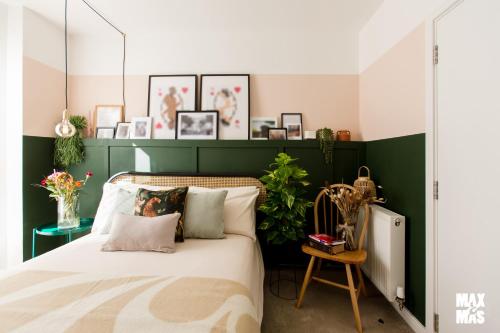 1 dormitorio con cama y pared verde en Charming 2-Bed with private balcony & free parking, en Dagenham