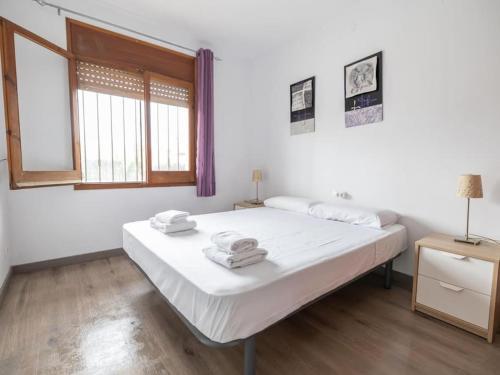a white bedroom with a bed and a window at Espectacular casa con piscina en Tordera in Tordera