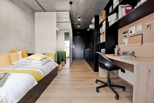 een slaapkamer met een bed en een bureau. bij SHED Living Kraków in Krakau