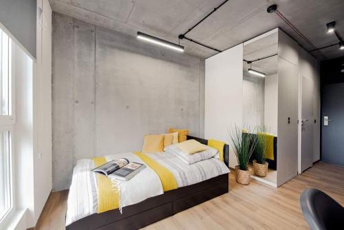 1 dormitorio con 1 cama grande con sábanas blancas y amarillas en SHED Living Kraków en Cracovia