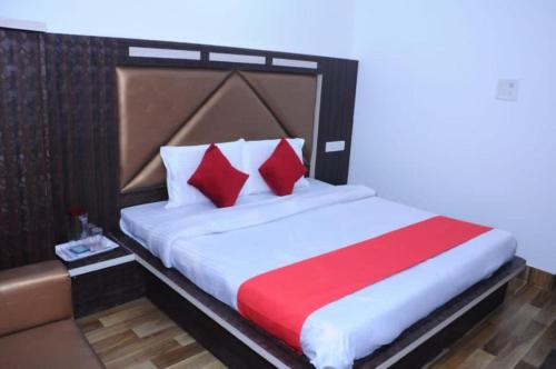カトラにあるHotel Lords Paradise , Katraのベッドルーム1室(大型ベッド1台、赤と白の枕付)