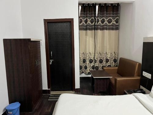 a room with a bed and a desk and a door at Hotel Lords Paradise , Katra in Katra