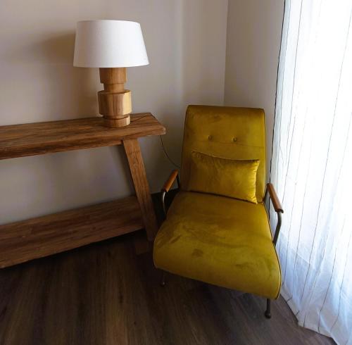 a yellow chair sitting next to a table with a lamp at Milè in Bari