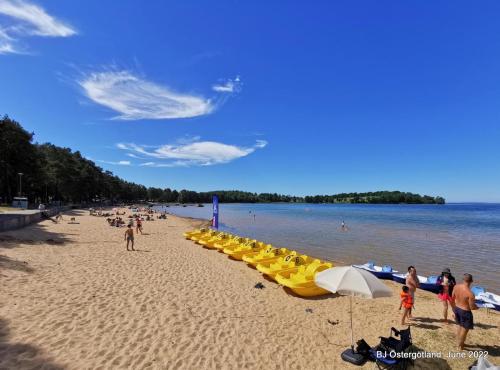 a beach with a bunch of yellow umbrellas and people at Paradise House in Motala