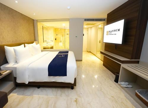 a hotel room with a large bed and a flat screen tv at Platinum Hotel Jimbaran Beach Bali in Jimbaran