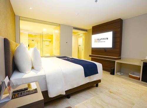a hotel room with a bed and a television at Platinum Hotel Jimbaran Beach Bali in Jimbaran