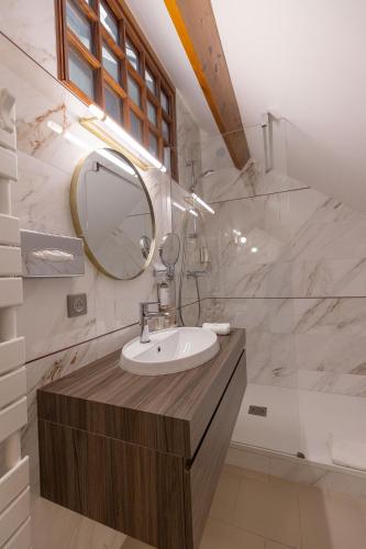 a bathroom with a sink and a mirror at Ferme de la Rançonnière - Hôtel & Restaurant in Crépon