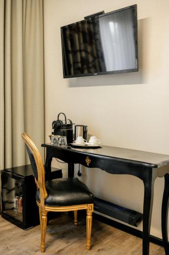 a black desk with a chair and a television on the wall at Weekend Boutique Hotel in Chişinău