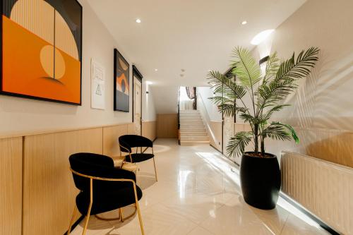 a waiting room with a potted plant and chairs at Weekend Boutique Hotel in Chişinău