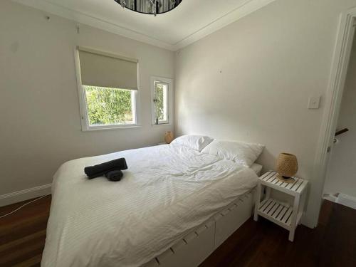- une chambre dotée d'un lit blanc avec un sac noir dans l'établissement 3 Bedroom House Family Friendly Surry Hills 2 E-Bikes Included, à Sydney
