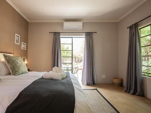 1 dormitorio con cama y ventana grande en The Blyde Canyon House en Hoedspruit
