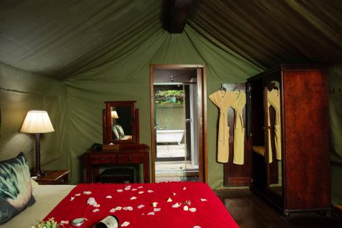 a bedroom with a tent with a bed and a mirror at Falaza Game Park and Spa in Hluhluwe