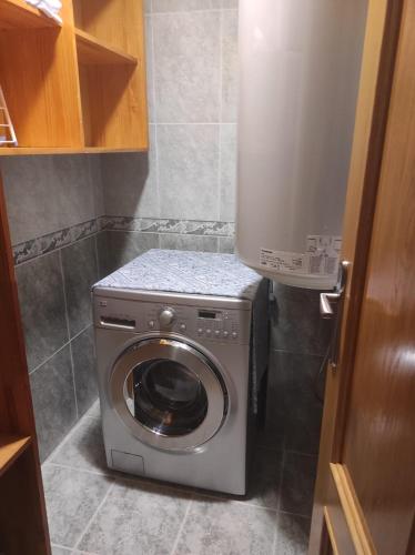 a washer and dryer in a small bathroom at Pedaporta in Combarro
