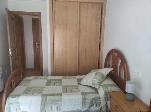 a bedroom with a bed and a table with a lamp at Pedaporta in Combarro