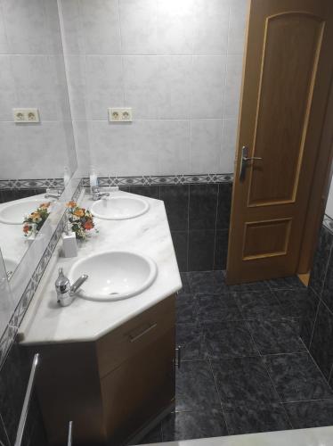 a bathroom with two sinks and a mirror at Pedaporta in Combarro
