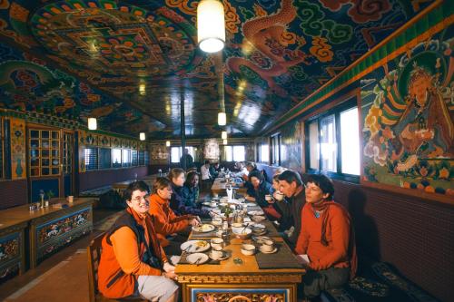 grupa ludzi siedzących przy stole w restauracji w obiekcie Mountain Lodges of Nepal - Lukla w mieście Lukla