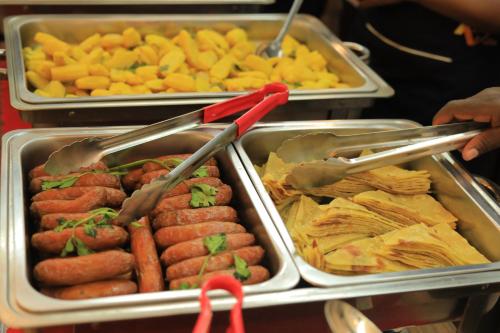 a tray of food with hot dogs and other foods at Precious Villas Lubowa in Kampala