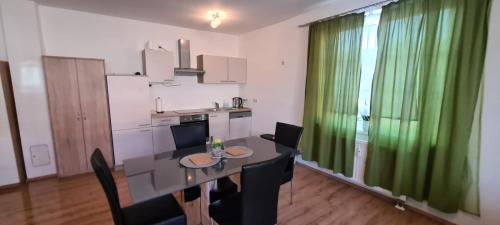 a kitchen and dining room with a table and green curtains at Vermietung D&S in Kapfenberg