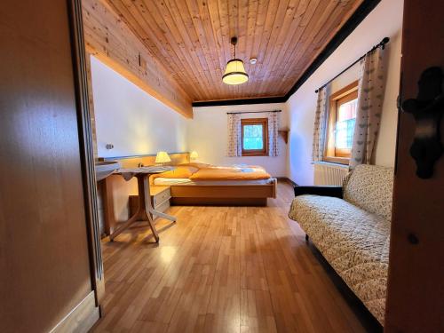 a bedroom with a bed and a couch in a room at Bauernhaus Stampfer in Sankt Lorenzen ob Murau
