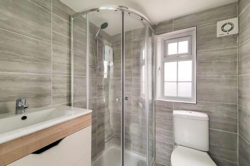 uma casa de banho com um chuveiro, um WC e um lavatório. em Lovely 3-bedroom 2 bath duplex flat in SE London em Chislehurst