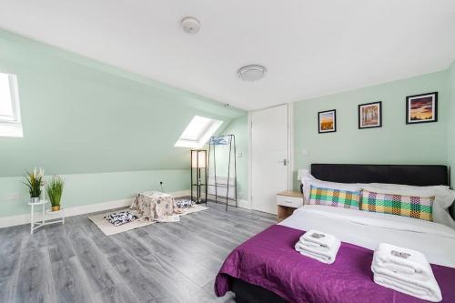 a bedroom with a large bed with a purple blanket at Lovely 3-bedroom 2 bath duplex flat in SE London in Chislehurst