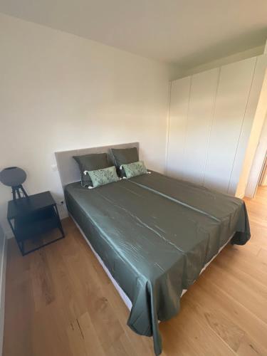 Un dormitorio con una gran cama verde y una silla en Maison moderne à Carbon Blanc, en Carbon-Blanc