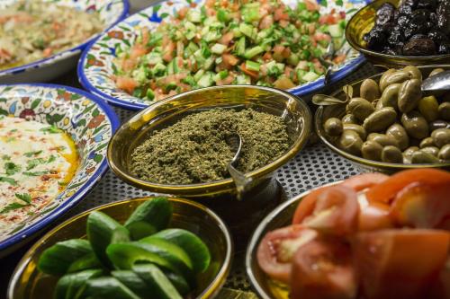 a table topped with plates of different types of food at The American Colony Hotel - Small Luxury Hotels of the World in Jerusalem