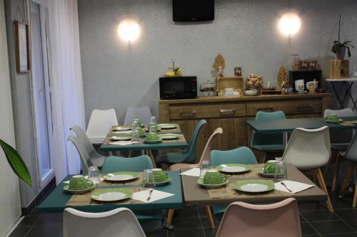 Un comedor con mesas y sillas con platos verdes. en City Lodge Appart Hôtel Niort, en Niort