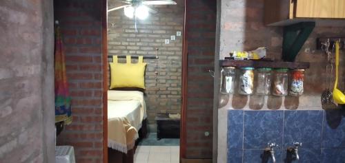 1 dormitorio con cama y pared de ladrillo en Casa En Cura Brochero Para Una Familia De 5/6 Pers. Todas las comodidades en Villa Cura Brochero