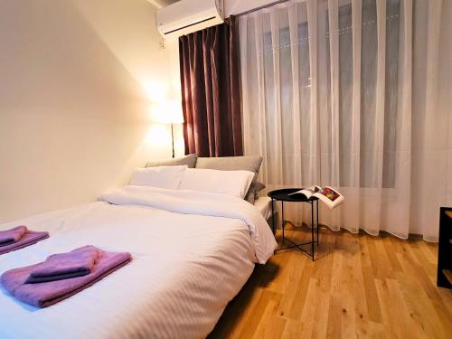 a bedroom with a bed with two towels on it at Modern & Stylish - Art Atelier Apartment in Skopje