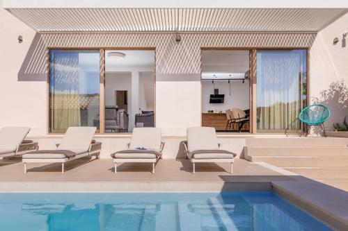a swimming pool with lounge chairs and a house at Brand New Villa Carmelita Exclusive with free Smart Car in Dubrovnik