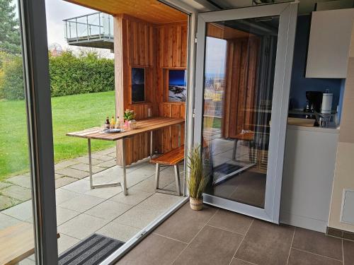 a sliding glass door leading into a kitchen with a table at Baumhaus und Tinyhaus in Mühlhausen