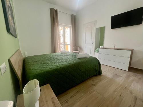 um quarto com uma cama verde e uma janela em AFFITTACAMERE IL TEATRO em Crotone