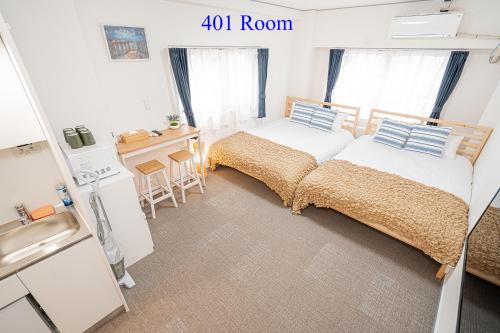 a small bedroom with two beds and a kitchen at UENO station 7min on foot/Cozy Apartment/Convenient location in Tokyo