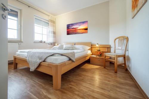 a bedroom with a bed and a chair at Friedenstraße 7 Whg 4 in Zingst