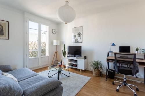 a living room with a couch and a desk at Joli 2 pièces avec balcon. in Boulogne-Billancourt
