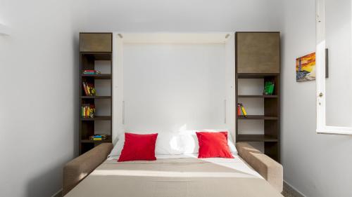 a bedroom with a bed with red pillows on it at VILLA MERAVIGLIA 8, Emma Villas in Nisporto