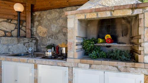 a stone kitchen with a sink and a counter top at VILLA MERAVIGLIA 8, Emma Villas in Nisporto