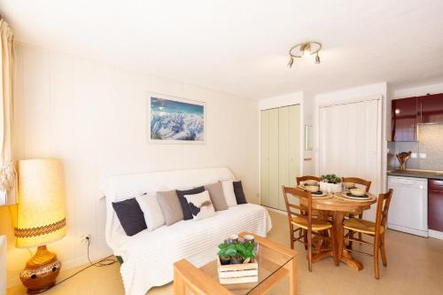 a living room with a bed and a table at Bel Appt Plein Coeur de Saint Lary Soulan in Saint-Lary-Soulan