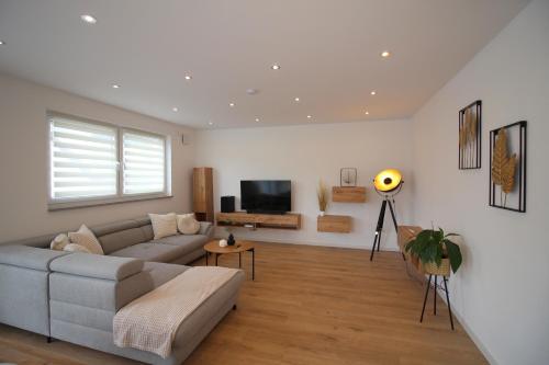 a living room with a couch and a tv at ADA, Ferienwohnung, 6-8 Personen, Parkplatz am Haus, modern, mit Dachterrasse in Kulmbach